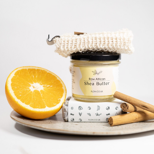 An Eco Body Gift Set of shea butter, beautifully presented with orange slices and cinnamon sticks on a plate.