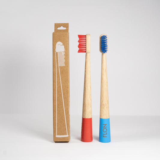 Two FLON Kids Bamboo Toothbrushes inside an eco-friendly cardboard box for an environmentally conscious dental care experience.