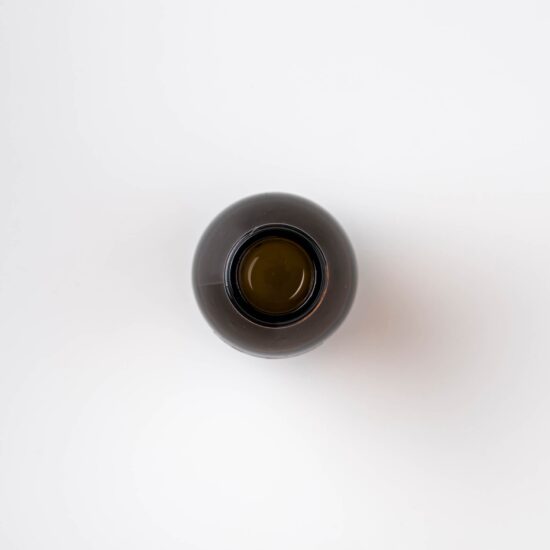 Top view of a 100ml amber bottle of Bristolmade Rose Geranium Micellar Water, showing the liquid of vegan ingredients for makeup removal and cleansing.