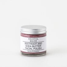 Photo of Bristolmade exfoliating face scrub, showing the pink blend of natural ingredients and gentle exfoliating particles. Packaged in a 60ml clear glass jar, with a white label, clearly indicating the products purpose and benefits.