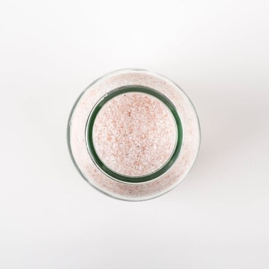 photo of the top view of a jar of bath salts, showing the pale pink grains of the epsom and himalayan salts.