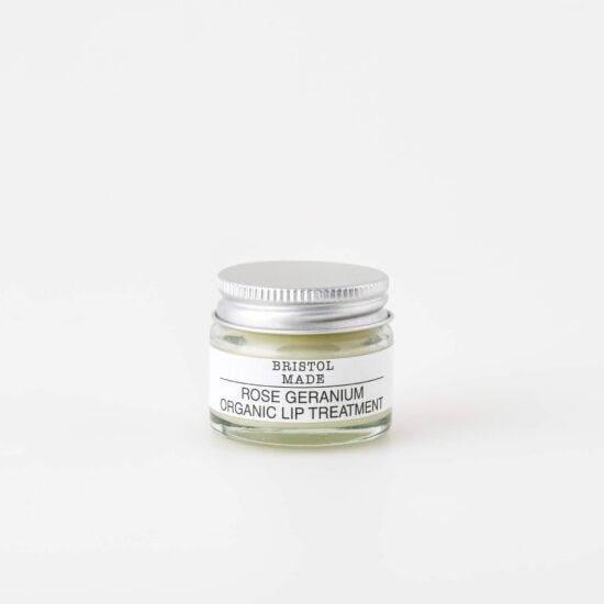 an image of a Bristolmade lip balm, packaged in a 15ml sustainable glass jar. With a white label and black text listing the natural ingredients.