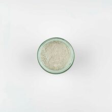 photo of the top view of a pale green powder, shows the fine particles, in a clear glass jar.