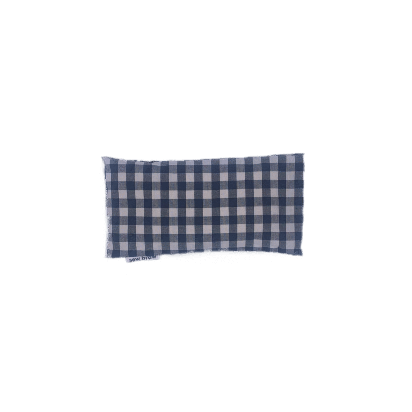 Photo of a black and white check cotton eye pillow on a white background.
