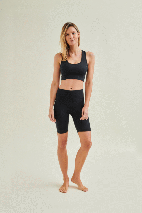 Woman wearing circular design black yoga shorts and black yoga bra by Wellicious styled for Pilates and fitness in breathable, non-toxic fabric