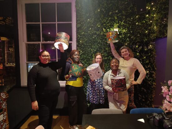People holding up their African lampshades after making them