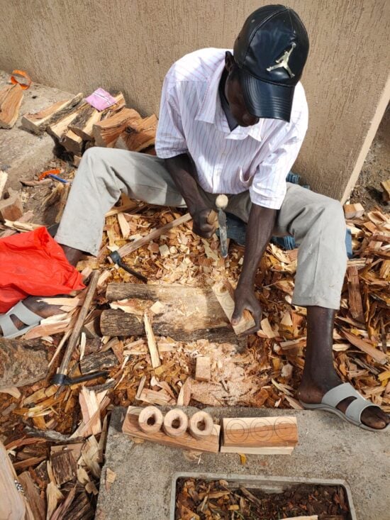 Artisan in Kenya handcarving wooden items