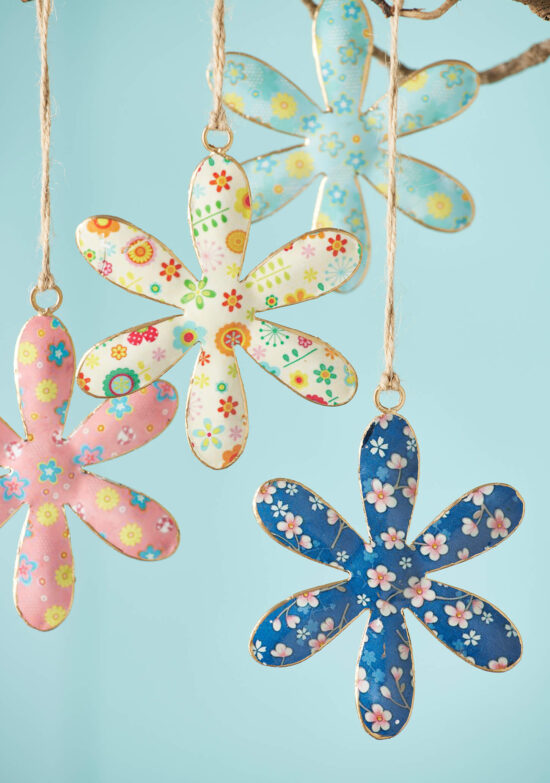 Several Hanging hand-painted metal daisy decorations in different colours, crafted by artisans in India. With a Floral print, gold-coloured edge, jute cord.
