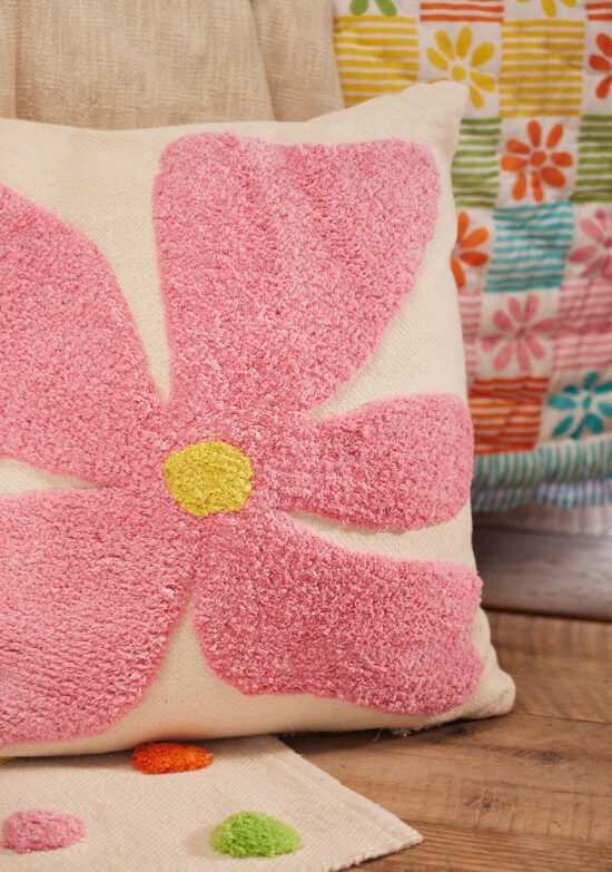 Large hand tufted bold flower cushion cover in pink on a natural recycled cotton base, with a yellow tufted centre. 55x55cm, handmade in India.