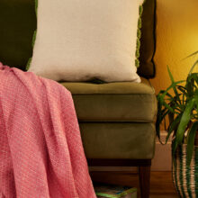 Showing the plain back of the Hand tufted palm leaf cushion cover in green on a natural recycled cotton base, with a large frond design in tufted pile. 45x45cm, handmade in India.