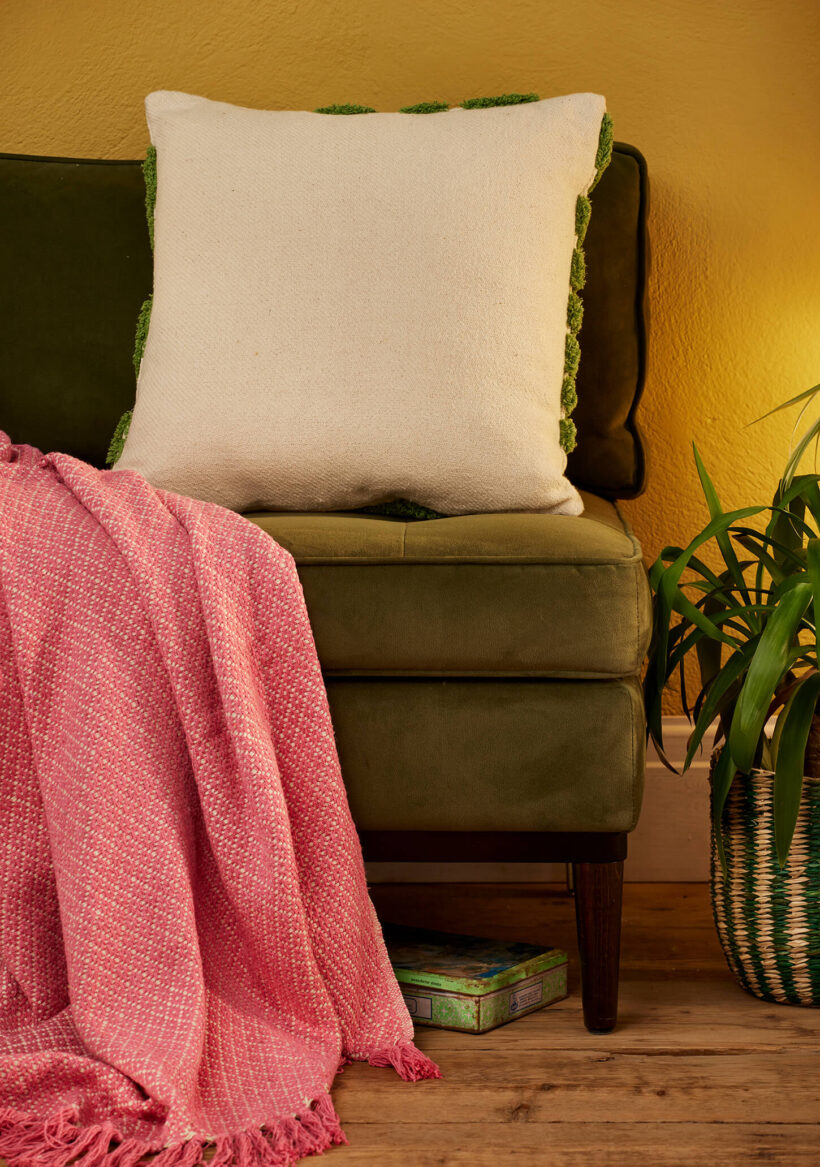 Showing the plain back of the Hand tufted palm leaf cushion cover in green on a natural recycled cotton base, with a large frond design in tufted pile. 45x45cm, handmade in India.
